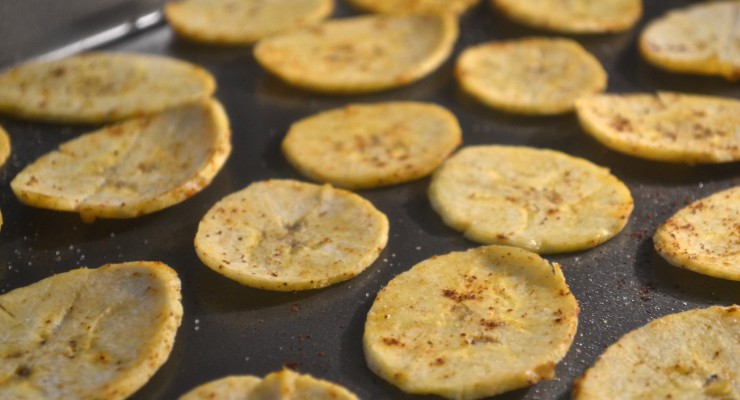 Sliced and seasoned plantain chips ready to roast.